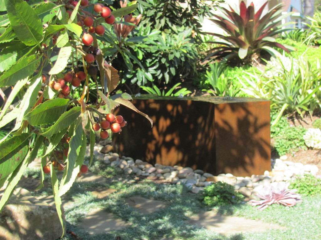 A naturally rusted cor-ten steel fountain in the front garden