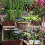 A naturally rusted steel water feature draws attention in this garden